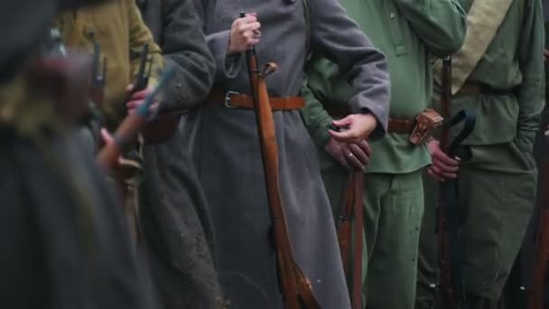 Чоловіки солдати в пальто, стоячи в ряді, тримають зброю — стокове відео