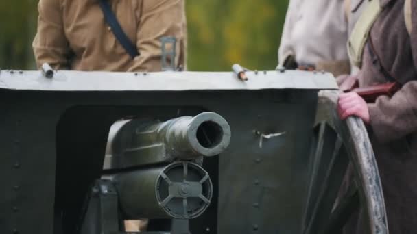 En militär man sätter ett maskingevär på plats på fältet — Stockvideo