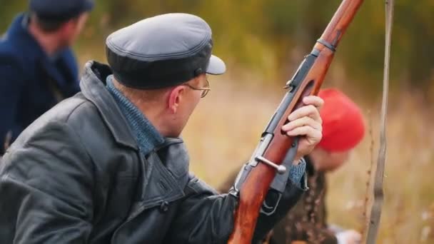 Un soldado sentado en una emboscada sosteniendo un arma — Vídeos de Stock