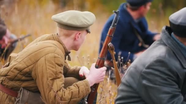 Katonák ülnek a rajtaütésben, fegyverrel a kezükben, és lőni készülnek. — Stock videók