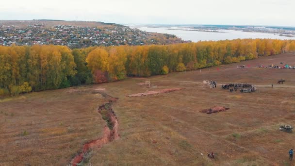 A reconstruction of military operations in Russia in 1917 - early autumn forest - yellow trees and a village on the background — Stock Video