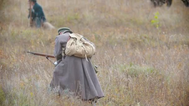 RUSSIA, REPUBLIC OF TATARSTAN 30-09-2019: A reconstruction of military operations in Russia in 1917 - man soldier looking around on the battlefield and leans to the ground crawling — ストック動画