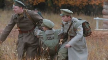 Rusya, Tataristan Cumhuriyeti 30-09-2019: 1917 'de Rusya' daki askeri operasyonların yeniden yapılandırılması - çatışmalar sahneleniyor - erkek askerler yoldaşlarını savaş alanından sürüklüyor