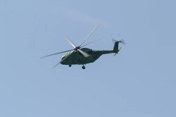 30 AUGUST 2019 MOSCOW, RUSSIA: A green military coloring helicopter with red star on the corpus flying in the sky - side view — Stock Photo, Image