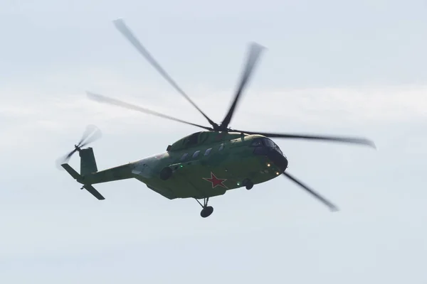30 августа 2019 г. МОСКВА, РОССИЯ: Зеленый военный вертолет с красной звездой на корпусе внизу, летящий в небе — стоковое фото