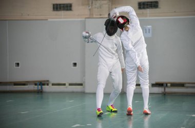 İki genç kadın eskrim eğitimi alıyor.