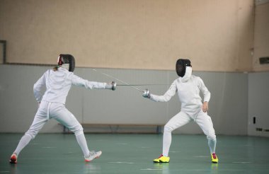 Spor salonunda eğitim gören iki genç kadın eskrimci.