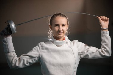 Tek bir çubuğu büken genç bir kadın eskrimcinin portresi.