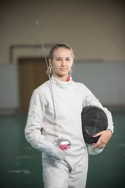 Una giovane donna sorridente schermitrice in piedi in palestra con spada e casco — Foto Stock