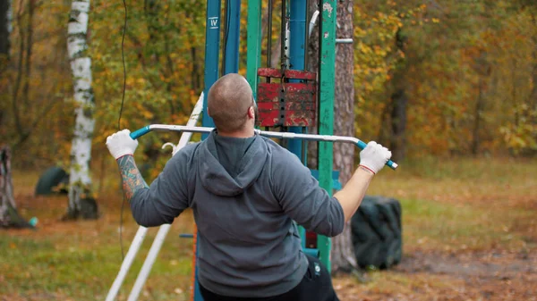 Açık spor sahasında bir adam vücut geliştirmeci eğitim - sonbahar ormanı — Stok fotoğraf