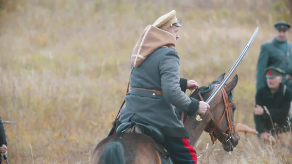 Soldado militar está montando un caballo con un arma en la mano — Foto de Stock