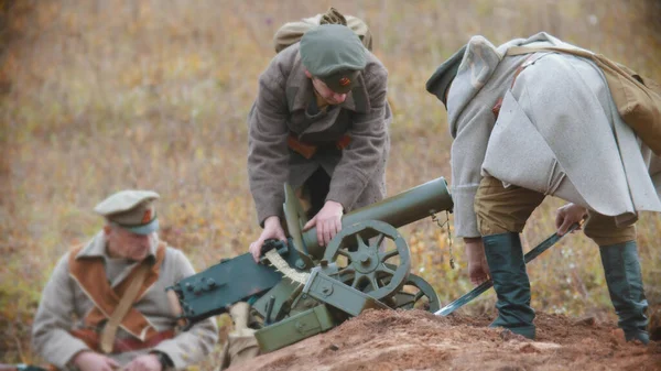 Солдаты на поле боя устанавливают пулемёт — стоковое фото