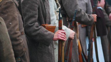 Savaş giysisi giymiş birkaç asker ellerinde silahlarıyla birbirlerine yakın duruyorlardı.