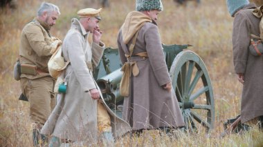 Askerler silah makinesinin yanında duruyor ve biri sigara içiyor.