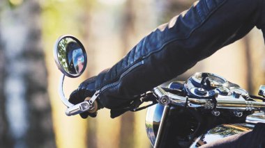 Motorcuların elleri onun havalı bisikletinin sapında.