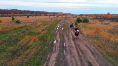 Yolda su birikintileriyle dört nala koşan iki kadın var.