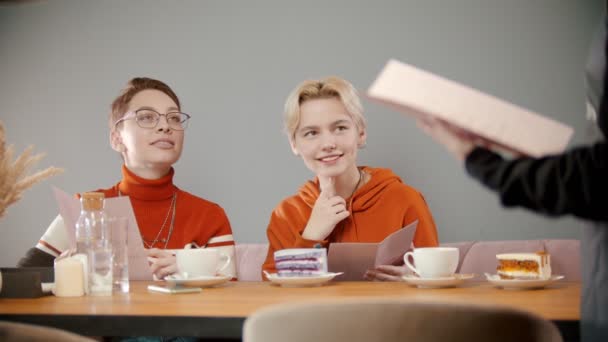 Meninas está olhando para o menu com o garçom — Vídeo de Stock