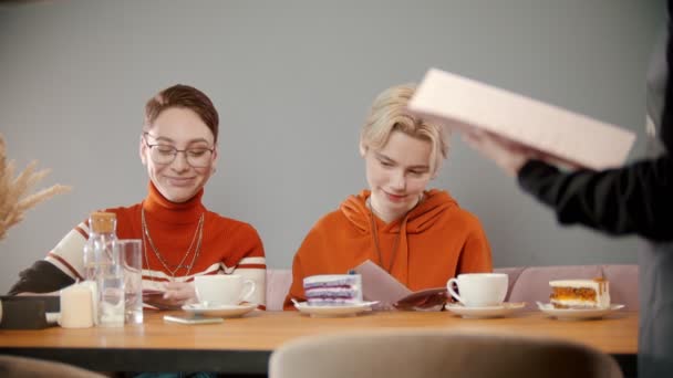 Meisjes geven het menu aan de ober. — Stockvideo