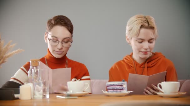 Девушки читают меню в кафе — стоковое видео