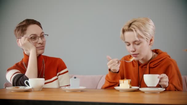 Meninas estão sentadas no café bebendo e comendo — Vídeo de Stock