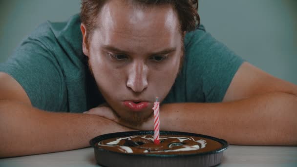Triste hombre no puede soplar la vela en el pastel — Vídeos de Stock