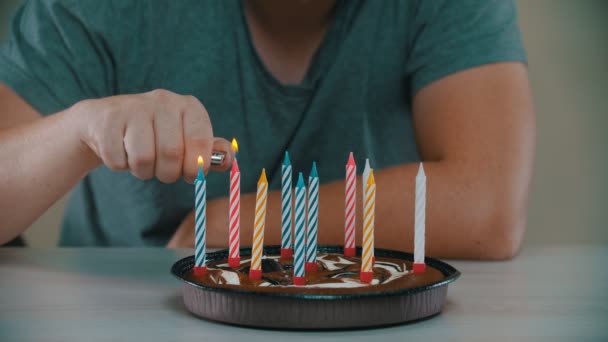 El hombre enciende velas en un pastel — Vídeo de stock