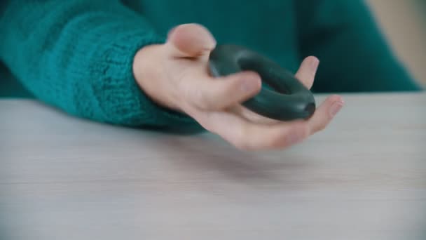 Een man knijpt een expander in zijn hand — Stockvideo