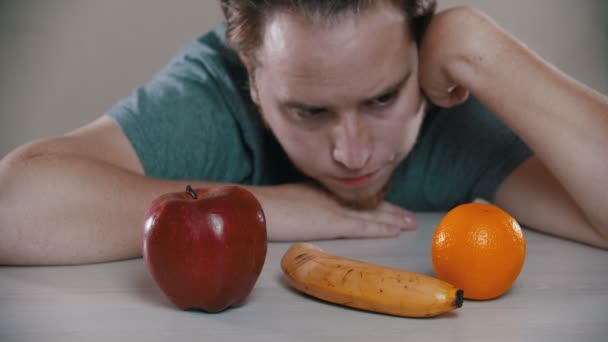 Un homme triste regarde les fruits — Video