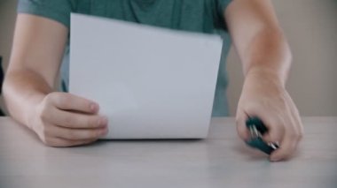 Bir adam gergin bir şekilde zımbayla kağıt bağlıyor.