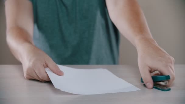 Человек прикрепляет бумагу степлером — стоковое видео
