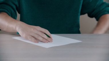 A man is actively writing word on a paper