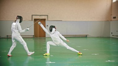 Okulun spor salonunda iki güzel eskrimci kavga ediyor.