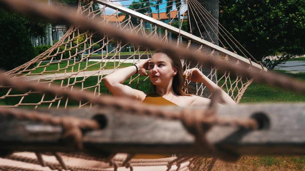 Bella giovane donna sta guardando a sinistra in amaca e sorridente — Foto Stock