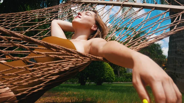 Bella giovane donna sta dormendo in amaca e la sua mano è appesa — Foto Stock