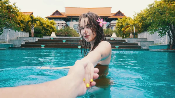 若い女性は水泳プールで男の手を握っている — ストック写真