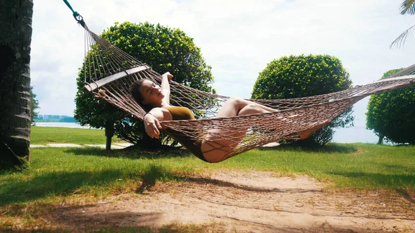 Mulher bonita está dormindo em rede espalhada — Fotografia de Stock