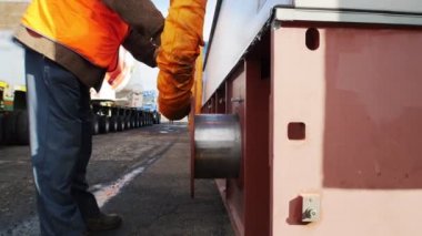 Kargo nakliyesi işçisi. Esnek tüpü tamir ediyor.