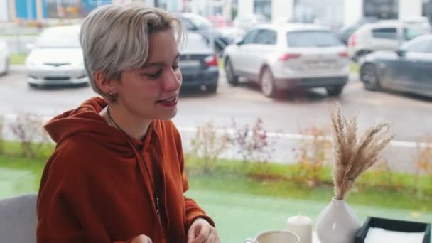 Красотка рассказывает о своих новостях в кофейне — стоковое видео