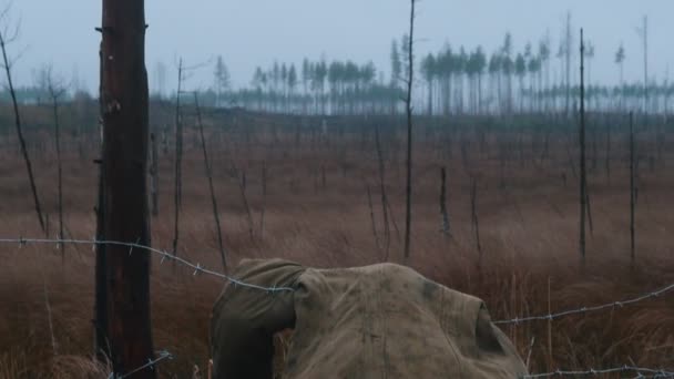 Soldado muerto tendido en el alambre de hierro - bosque quemado — Vídeos de Stock