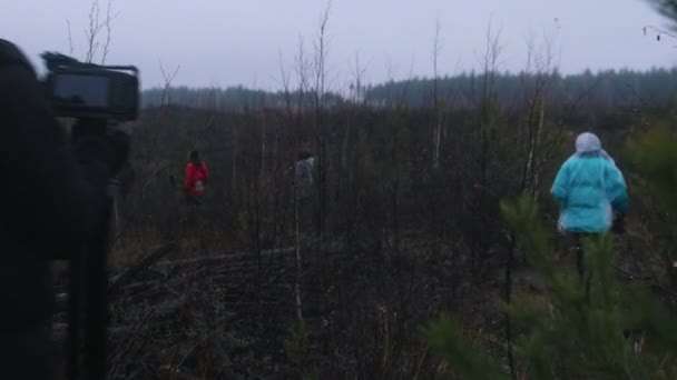 撮影の背景 – 曇りの森とパスを歩く撮影チーム — ストック動画