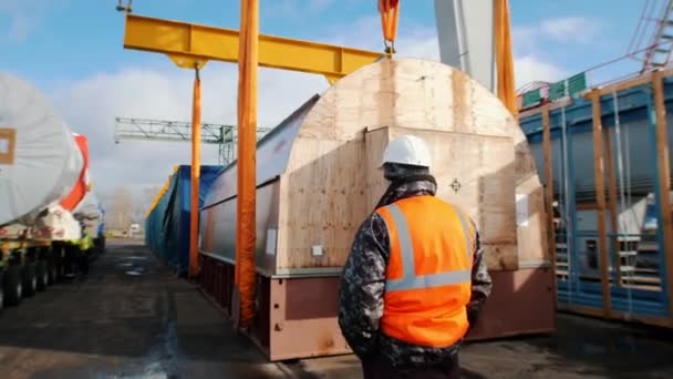 Cargo shipping - a man worker standing on the construction site — Stock Video