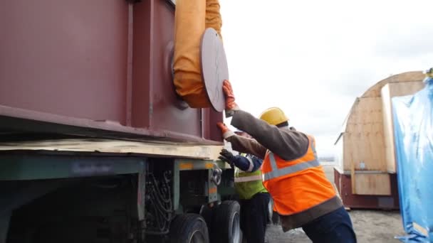 Lasttransport - män som arbetar på byggarbetsplatsen - hjälper till att sätta lasten i montern — Stockvideo