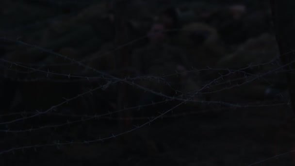 Wounded soldier crawling under the wire iron at night — Stock Video