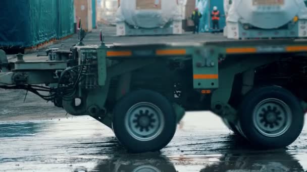 Un grand camion d'expédition qui passe sur le chantier - des travailleurs hommes debout sur le fond — Video