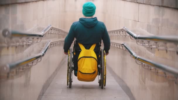 Gehandicapte man in rolstoel komt van de lange speciale helling — Stockvideo