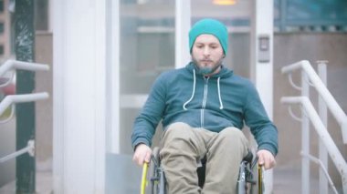 Tekerlekli sandalyedeki engelli adam engelliler için özel asansörden çıktı.