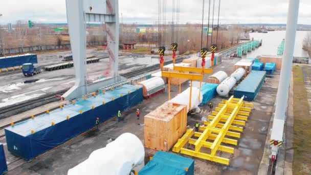 Cargo port - A big industrial crane unloading the cargo from the freight carriage on rails — Stock Video