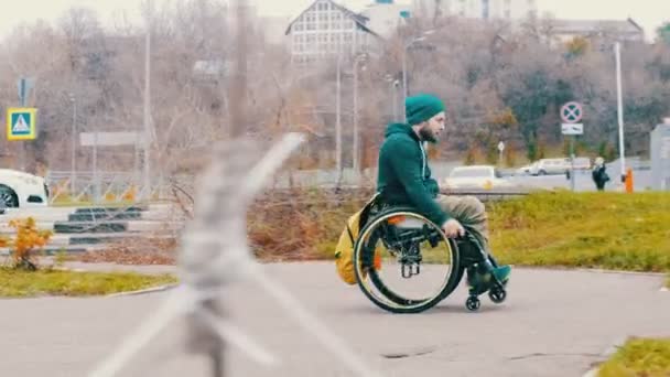 Behinderter im Rollstuhl versucht, seinen Rollstuhl über eine Rampe auf der Straße zu lenken, rollt aber zurück — Stockvideo