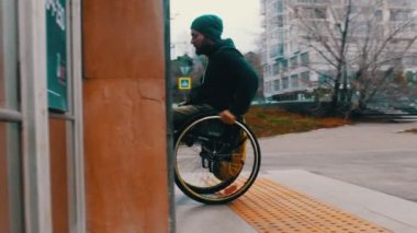 Tekerlekli sandalyedeki engelli adam metro kapısından giriyor.