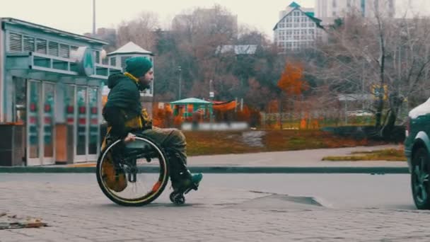 Zdravotně postižený muž na invalidním vozíku sestupuje po rampě z pěšiny a vrací se — Stock video